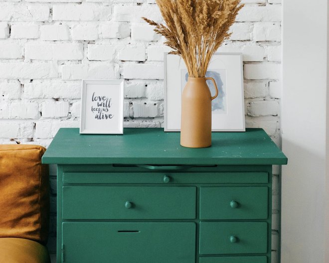 Green chest of drawers with decorative items